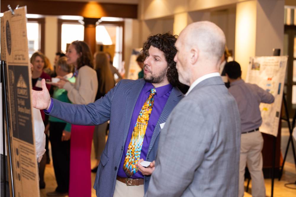 Anton (left) presenting to Dr. Jeffrey Potteiger (right) at the 2023 Graduate Showcase.